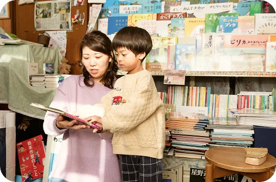 親子で一緒に絵本を読みながらページをめくる様子